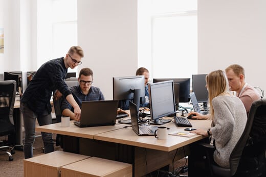 groupe de personnes au travail devant des ecrans d'ordinateurs