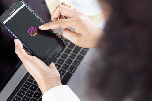 femme avec un telephone dans les mains sur dans les mains sur instagram